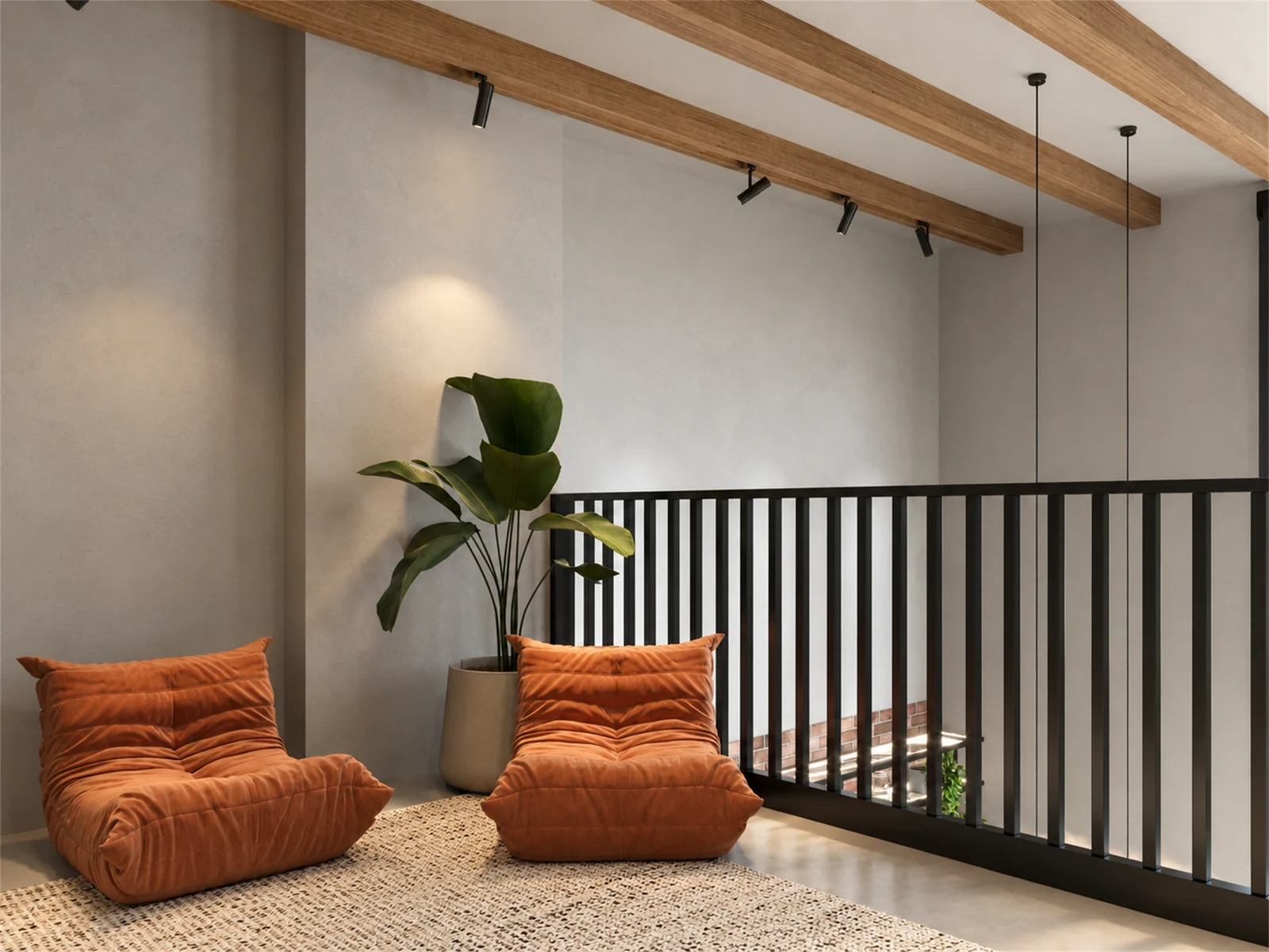 Mezzanine reading corner with rust-toned lounge chairs beneath timber beams