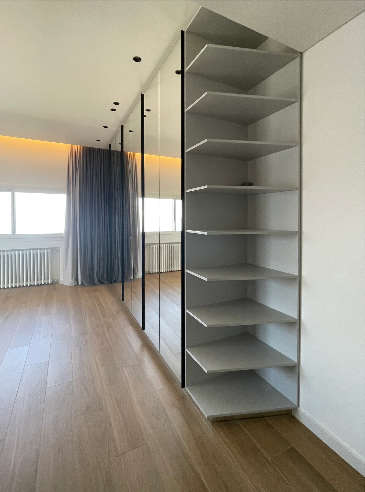 Open shelving beside mirrored wardrobes