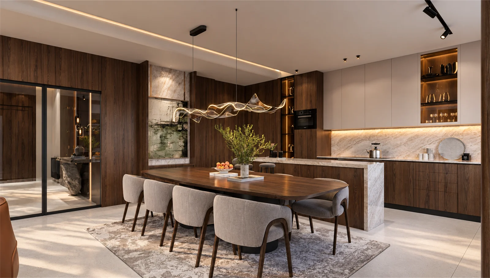 Dining area with upholstered chairs, a flowing pendant and softly lit kitchen cabinetry