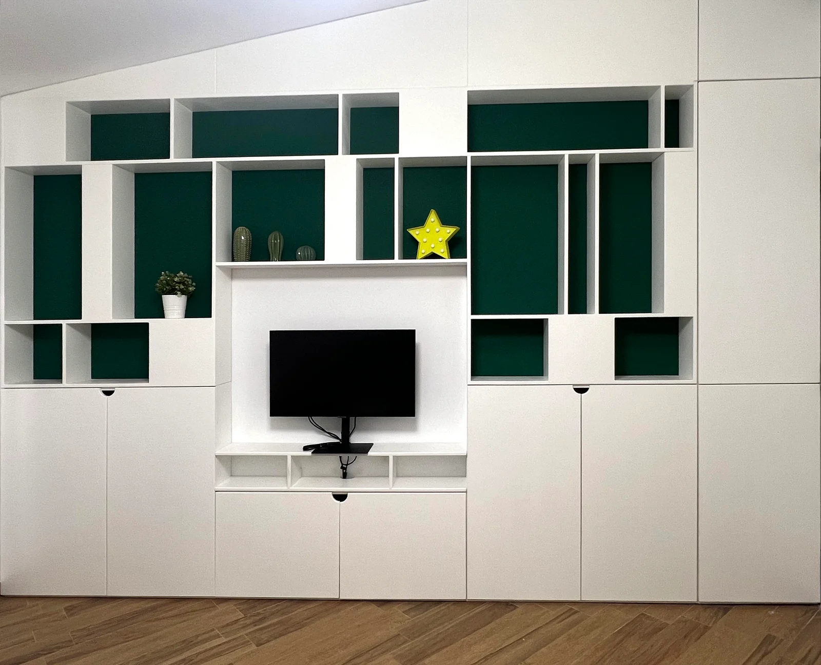 TV wall with geometric green shelving