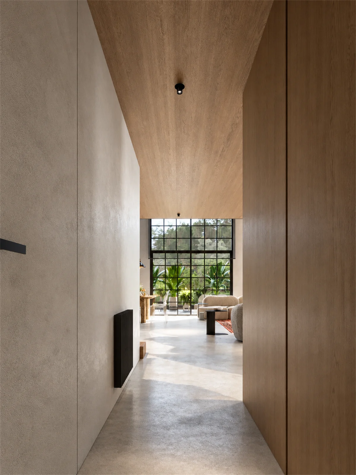 Timber-lined passage opening toward the sunlit living space