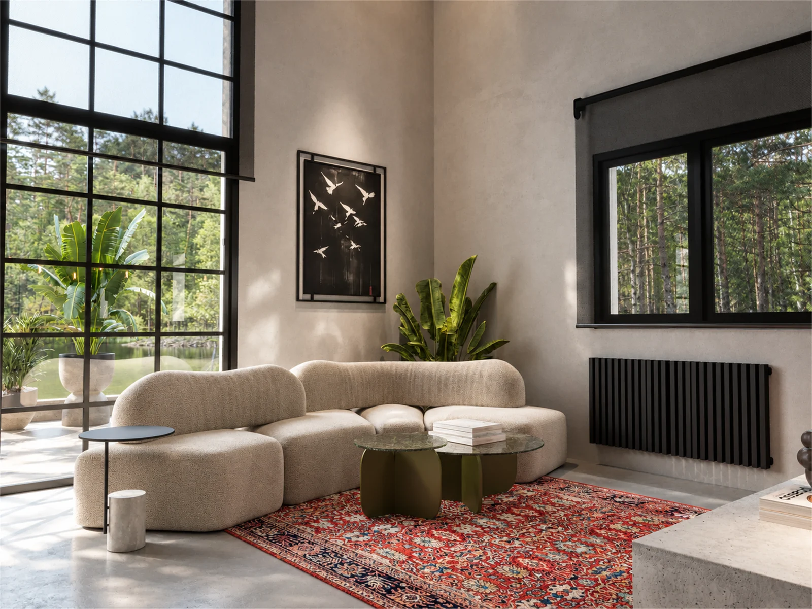 Curved neutral seating and sculptural tables anchored by a patterned red rug