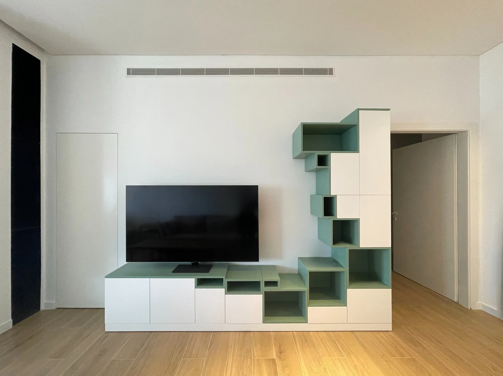 TV wall with sage-green shelving